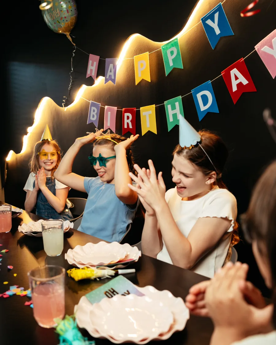 Kids cheering around the table at a Bond's birthday party