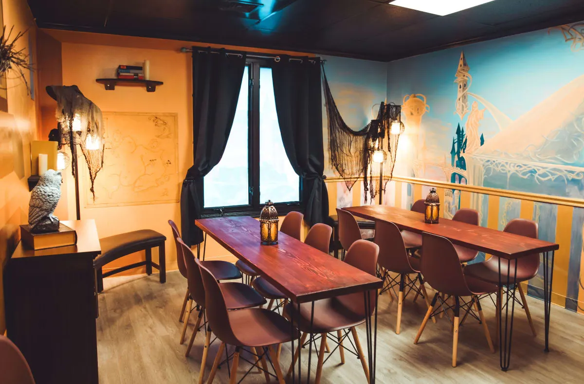 A private VIP party room at Bond's with two long wooden tables, wall sconces, a large mural and a stuffed owl on a side table