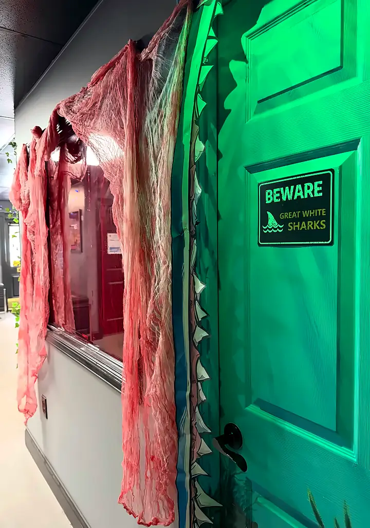 The corridor outside Bowl Voyage: Blood Bowl, with blood-red gauze draped over the window beside the shark door