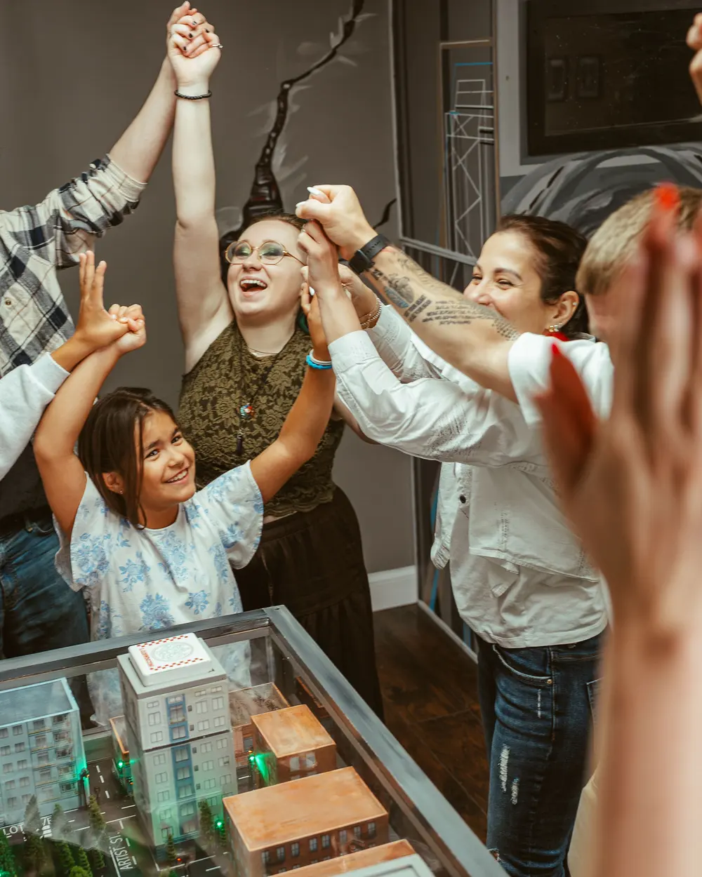A team throwing their hands up after escaping a room at Bond's