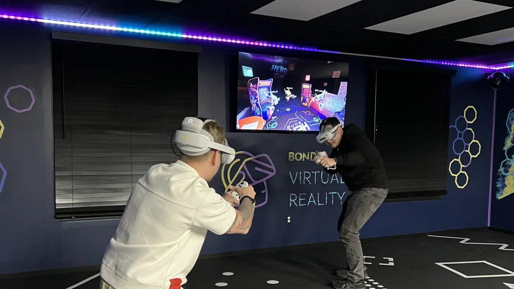 A large group splitting across both VR arenas at Bond's