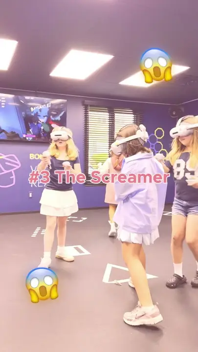 Friends in VR headsets in the arena, one of them shrieking in surprise
