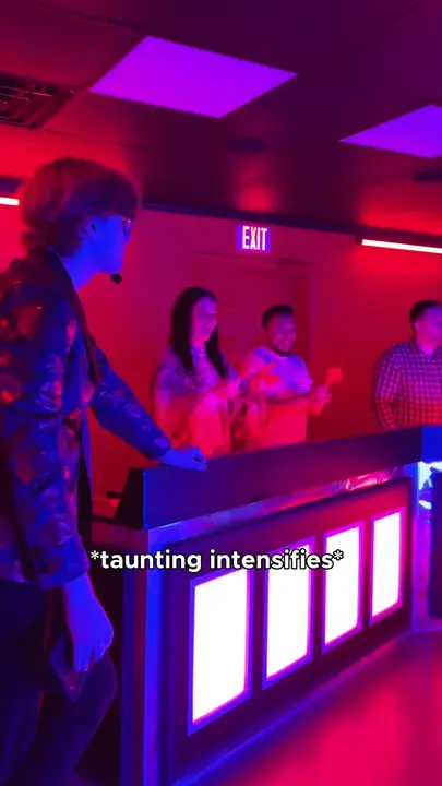 Players in red light behind the Game Show buzzers, with the caption "taunting intensifies"